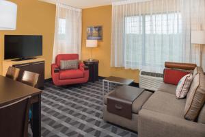 New HartfordTownePlace Suites by Marriott New Hartford的带沙发、椅子和电视的客厅