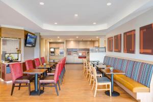 New HartfordTownePlace Suites by Marriott New Hartford的餐厅设有木桌和红色椅子