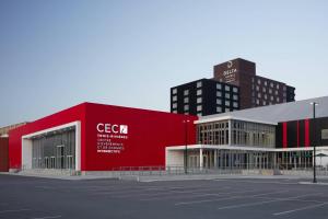 三河城三河城会议中心德尔塔酒店的一座红色的建筑,位于一座高楼城市