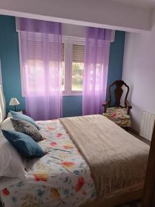 奥维多Casa Oviedo centro的一间卧室配有一张床和一个带紫色窗帘的窗户