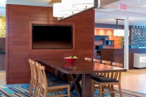 费舍尔Fairfield Inn & Suites by Marriott Indianapolis Fishers的一间带桌椅和电视的用餐室