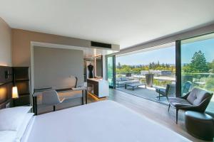 帕罗奥多AC Hotel by Marriott Palo Alto的一间带大床的卧室和一间客厅