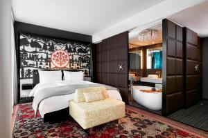 格拉特布鲁格苏黎世波恩卡梅哈格兰德签名收藏酒店的卧室配有1张床、浴缸和椅子