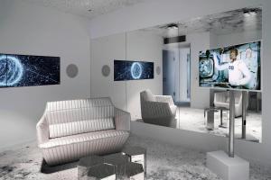 格拉特布鲁格苏黎世波恩卡梅哈格兰德签名收藏酒店的客厅配有电视、沙发和椅子