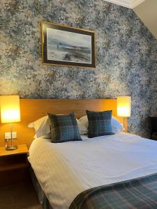 阿伯雷蒂Old Aberlady Inn的一间卧室配有一张带两盏灯的床。