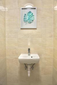 布达佩斯L&L HOME的一间带水槽的浴室和墙上的照片