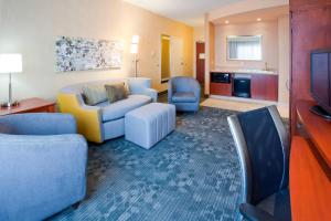 罗切斯特罗切斯特梅奥医学中心区区/圣玛丽万怡酒店的客厅配有沙发、椅子和电视