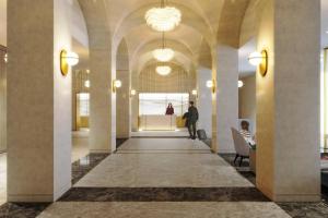 蒙特利尔尚普兰蒙特利尔万豪酒店的建筑物的走廊,有人沿着走廊走