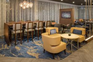 坦帕Marriott Tampa Westshore的餐厅设有酒吧,配有桌椅