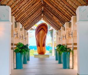莫雷洛斯港Margaritaville Island Reserve Riviera Cancún - An All-Inclusive Experience for All的走廊上大雕塑,有盆栽植物