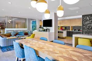 阿什维尔TownePlace Suites by Marriott Asheville West的一间带长桌和蓝色椅子的用餐室