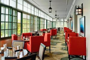 圣安德鲁斯圣安德鲁斯阿冈昆海滨度假酒店，奥图格拉菲系列的餐厅设有红色的椅子和桌子以及窗户。