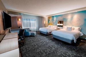 坦帕Courtyard by Marriott Tampa Northwest/Veterans Expressway的酒店客房设有两张床和一台平面电视。