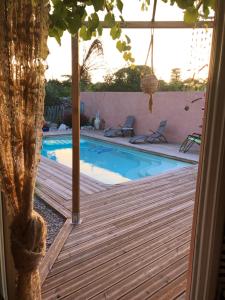 巴亚盖斯Villa des Oliviers的一个带木甲板和游泳池的游泳池