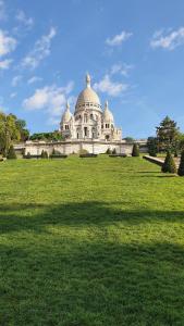 巴黎Chambre d'hôtes confort et charme Paris 9eme的草场中间的大建筑