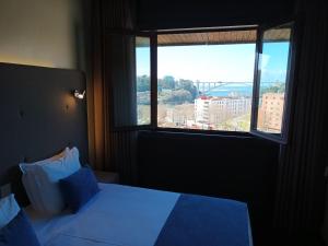 波尔图Vilar Oporto Hotel的一间卧室设有一张床和一个大窗户
