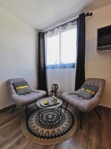 卡夫尔高原Côté Volcan的客厅配有两把椅子和一张桌子