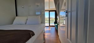 波瓦-迪瓦尔津Floating Experience - Casa flutuante a 25 min do Porto的一间卧室设有一张床,并有通往阳台的门