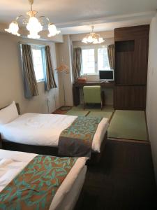 IidaHakuba Sun Valley Hotel Annex - Vacation STAY 90351v的酒店客房设有两张床和电视。