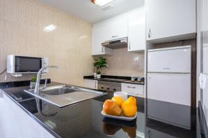 拉皮内达Alea Rentals - Los Juncos的厨房配有水槽和柜台上的果盘