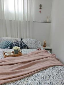 木洛希尼Apartment46的床上有毯子和一碗鲜花