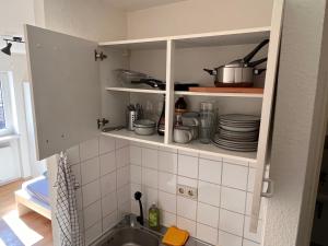 曼海姆Gemütlich Wohnen in der Neckarstadt的厨房配有水槽和带碗碟的橱柜