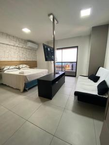 马塞约Apto TIME - vista mar em Ponta Verde Maceio的一间卧室配有两张床、一张桌子和一张沙发
