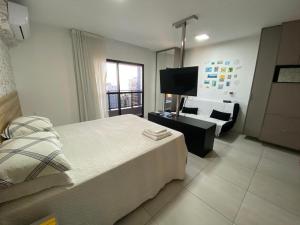 马塞约Apto TIME - vista mar em Ponta Verde Maceio的一间卧室配有一张床、一张沙发和一台电视