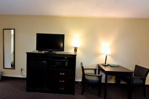 哥伦比亚Rodeway Inn Harbison Area的酒店客房设有电视和桌椅