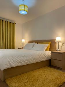 格雷斯瑟罗克Large Bed in a luxuriously furnished Guests-Only home, Own Bathroom, Free WiFi, West Thurrock的一间卧室配有一张大床,配有两盏灯和地毯