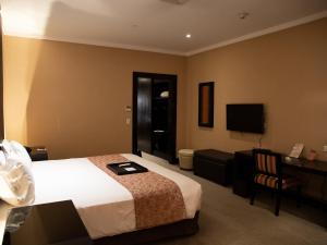 内乌肯赌场魔术酒店的配有一张床和一台平面电视的酒店客房