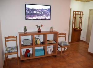 贝尔加Apartamentos loli的客厅配有两把椅子和墙上的电视