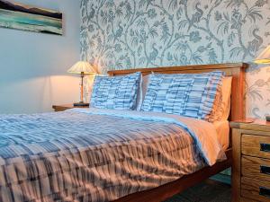巴拉Tegid Lakeside - Bala Lake的一间卧室配有一张带两个蓝色枕头的床
