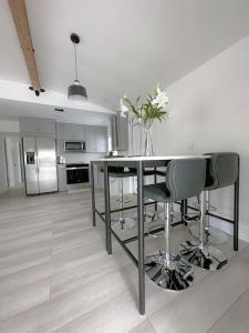 迈阿密Dream House 4B/2B King Bed Miami Springs, FL的厨房配有桌椅和冰箱。