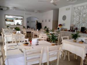 切塞纳蒂科B&b villa lambusta的一间设有白色桌子和白色椅子的餐厅