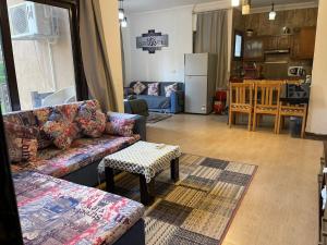 艾因苏赫纳Marsilia blue bay的带沙发和桌子的客厅以及厨房。