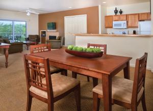 欧塞奇比奇奥沙克湖世誉酒店的厨房以及带木桌和椅子的客厅。