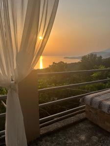 PiqerasRooms to let Spiropali的阳台配有窗帘,享有日落美景。