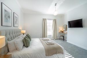 切斯特Southview Stays - Three bedroom House的白色卧室设有一张大床和电视。