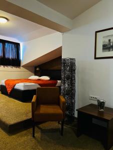 巴尼亚卢卡Stara Ada Banja Luka的一间卧室配有一张床、一把椅子和一张桌子