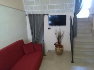 韦列Dimora San Biagio的客厅配有红色沙发和电视