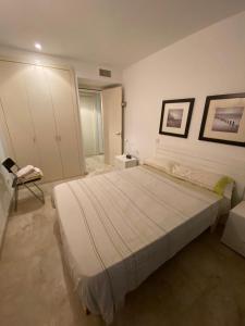 休达德亚Apart duplex Cala Busquets的一间卧室配有一张大床和一把椅子