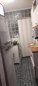瓜鲁柳斯Meire Hostel的厨房配有白色冰箱和台面
