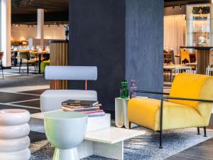 阿姆斯特丹Tribe Amsterdam City的一间设有两把椅子和一张桌子及书籍的房间