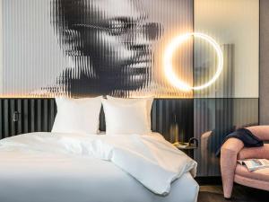 阿姆斯特丹Tribe Amsterdam City的卧室配有一张带男人照片的床