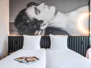 阿姆斯特丹Tribe Amsterdam City的墙上画画的房间里设有两张床