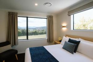 瓦纳卡Wanaka Top 10 Holiday Park的酒店客房设有一张床和一个大窗户
