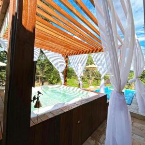 皮雷诺波利斯Pousada Aconchego的享有带木制凉亭的游泳池的景色
