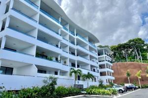 帕皮提Condo Airport Tahiti Faa'a的公寓大楼设有白色阳台和棕榈树