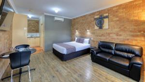 莫阿马梅尼亚大桥公寓式酒店的酒店客房配有一张床和一张皮沙发